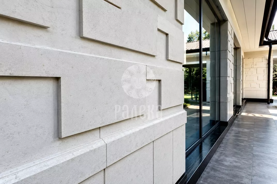 Three-dimensional geometric pattern on the stone cladding near the window opening.