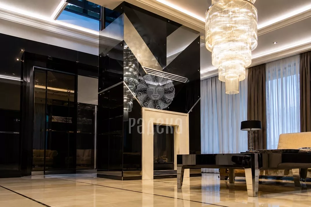 Fireplace in modern Art Deco style with Crema Marfil portal and dark geometric cladding in the residential complex 'Rublyovo Residence'.