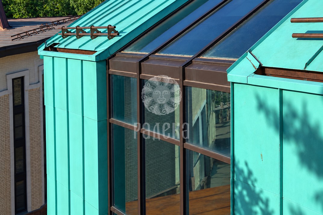 Junction of the copper roof and facade cladding with sloped and vertical glazing in Serebryany Bor.